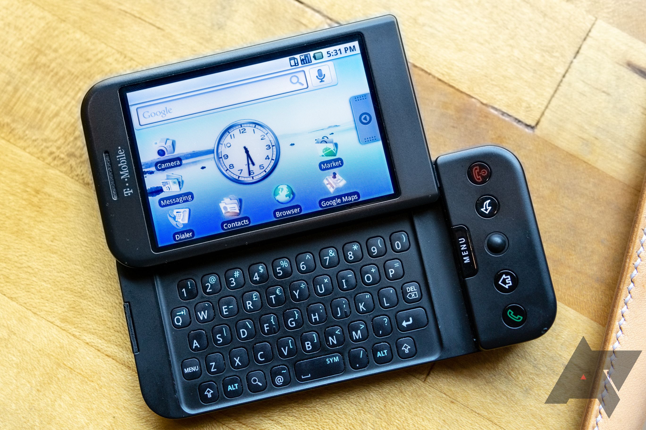 HTC Dream/T-Mobile G1 laying on desk with screen open and keyboard showing