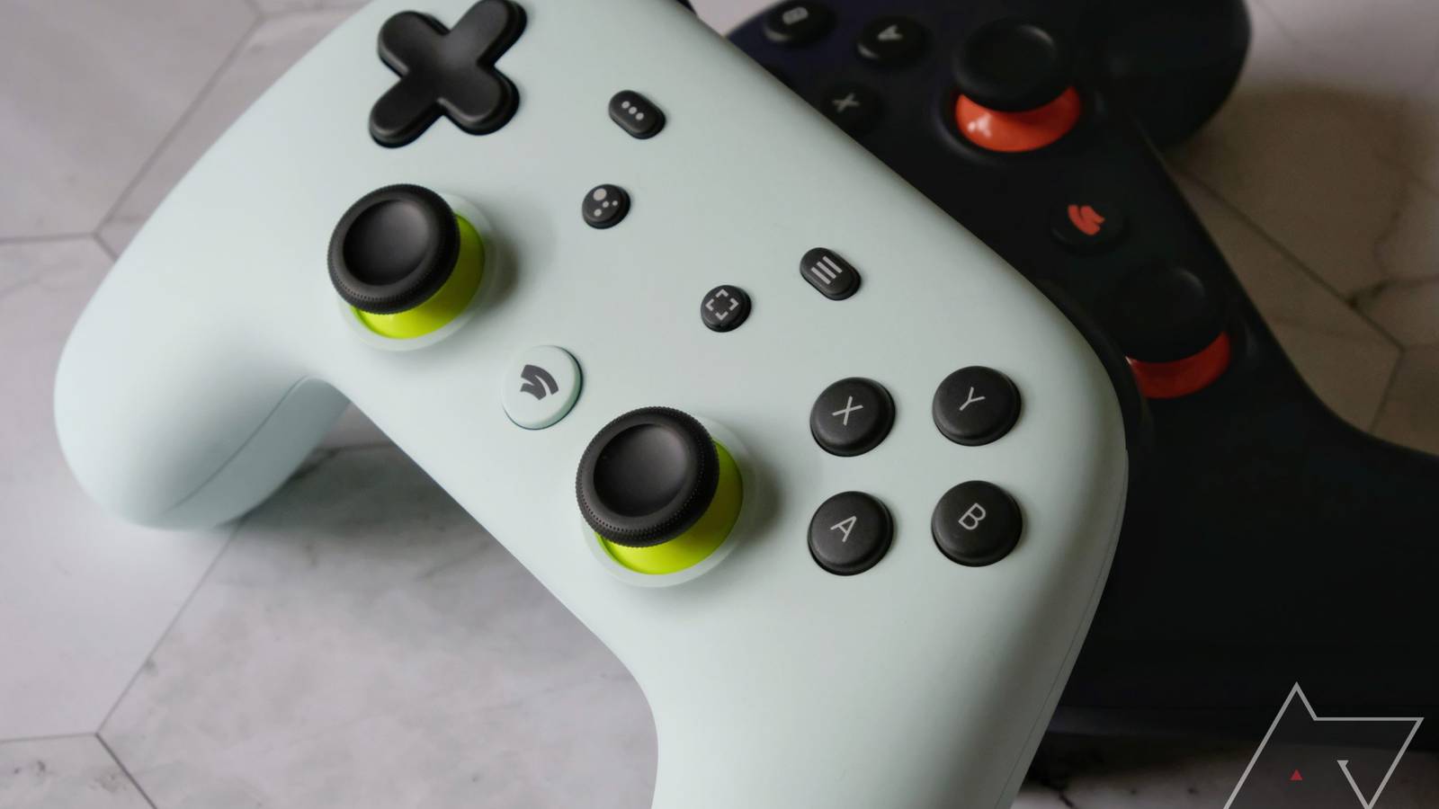 A Wasabi Green and Night Blue Stadia controller on a tile background