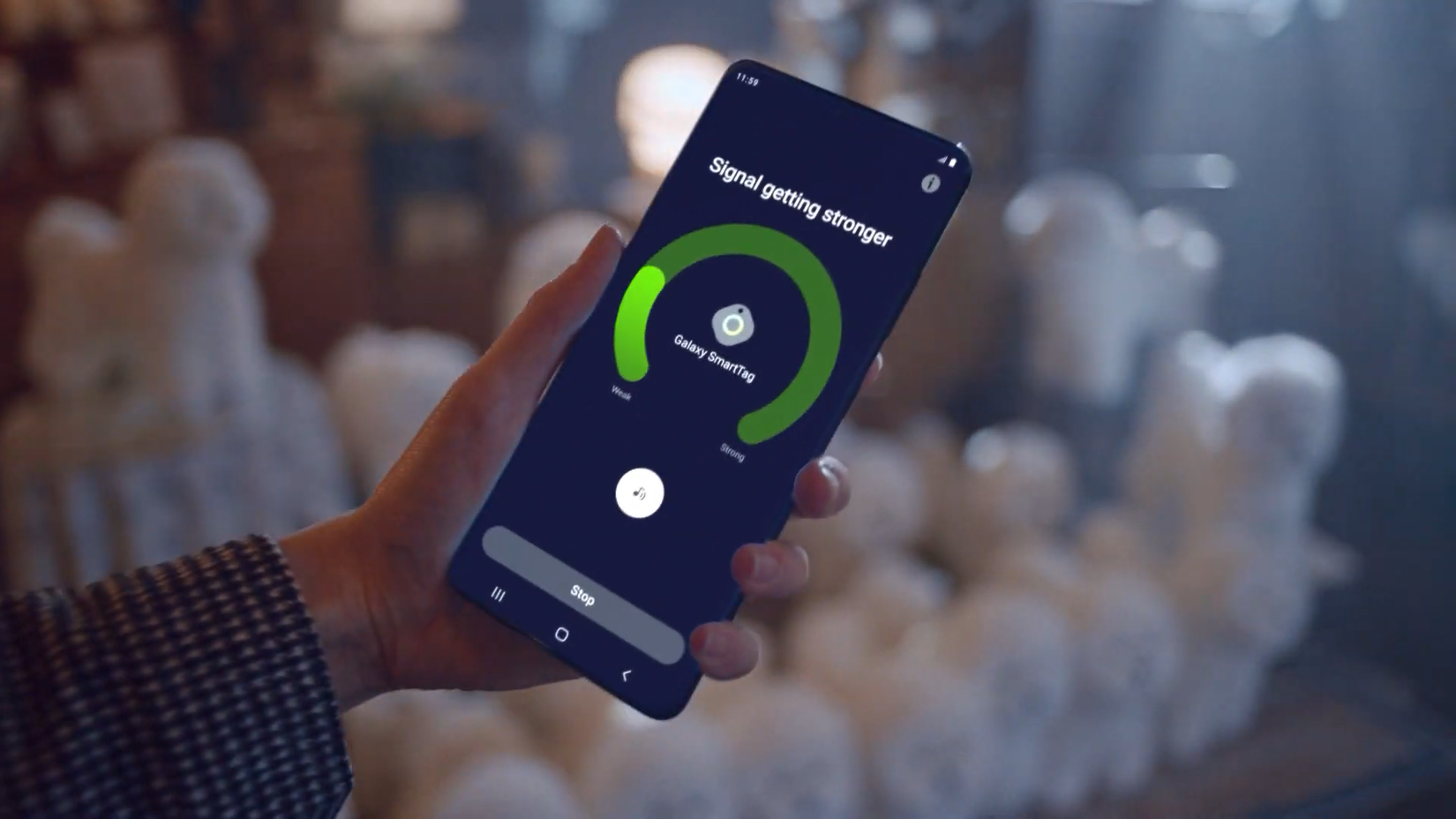 Uma pessoa segurando um smartphone com um aplicativo exibindo a intensidade do sinal do Galaxy SmartTag
