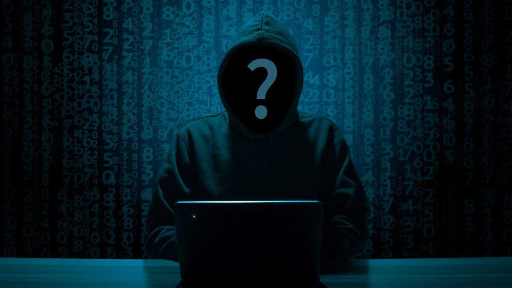 Hacker on a computer in a dark room.