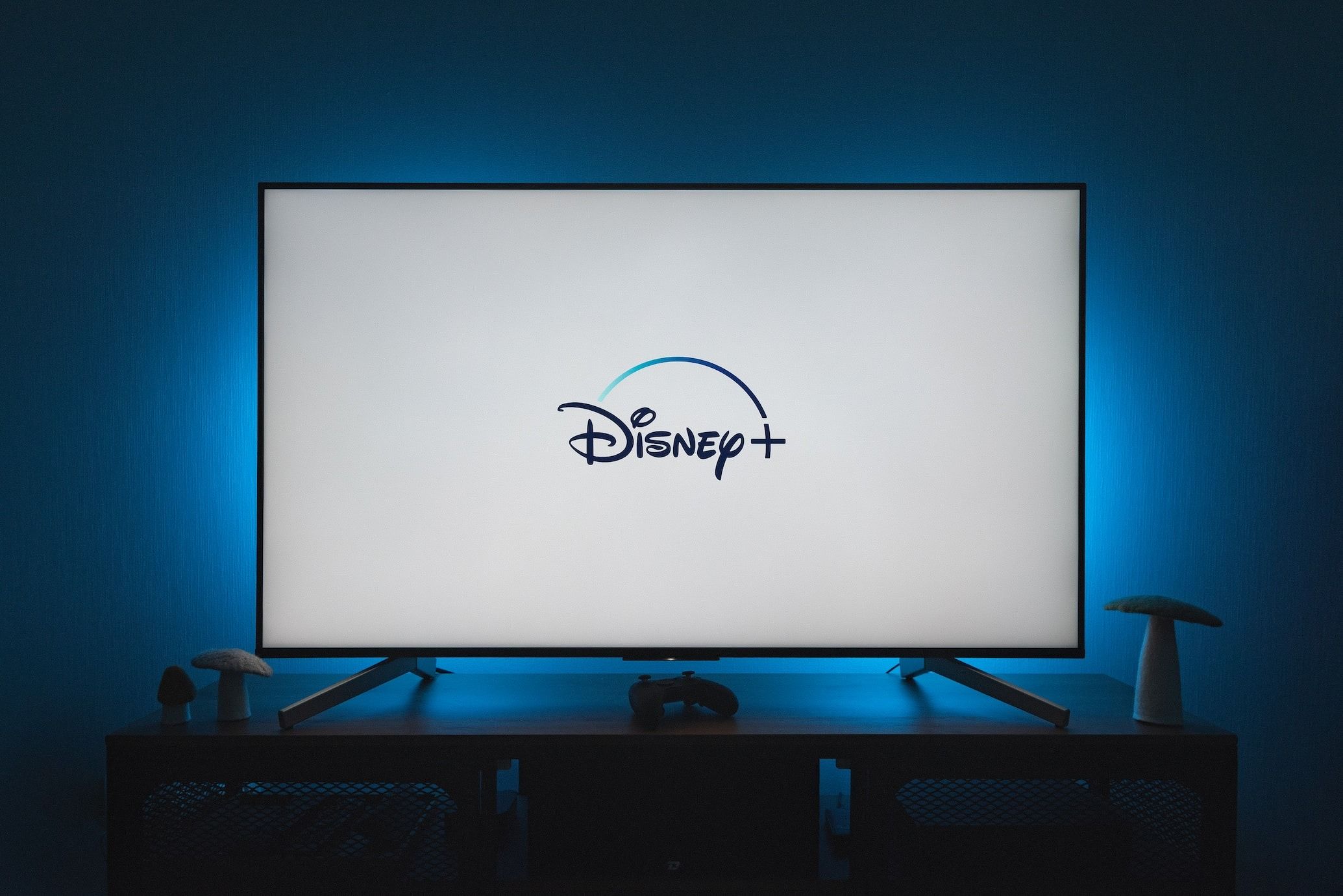 Disney Plus logo glowing on a modern television screen in a dark room
