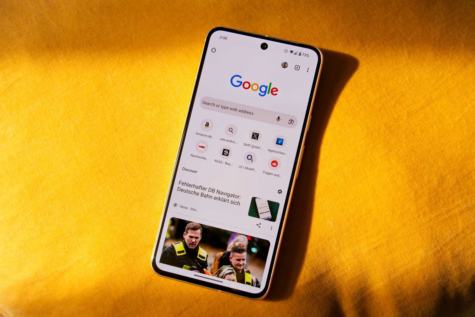 Google Pixel 8 su un tessuto giallo brillante con Google Chrome aperto