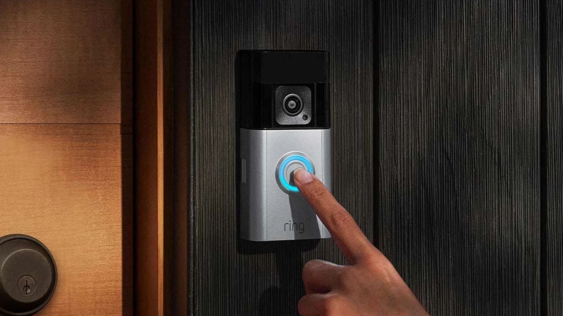 Someone ringing a Ring Battery Doorbell mounted on a black stained wood exterior