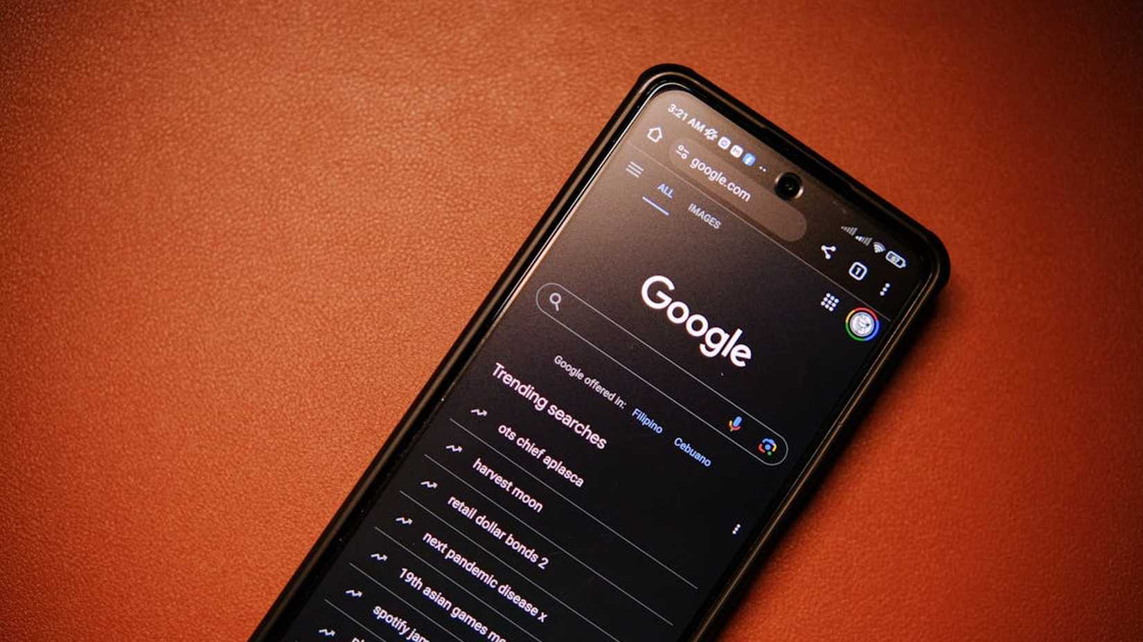 صفحة بحث Google في الوضع المظلم على هاتف ذكي على خلفية بلون الصدأ