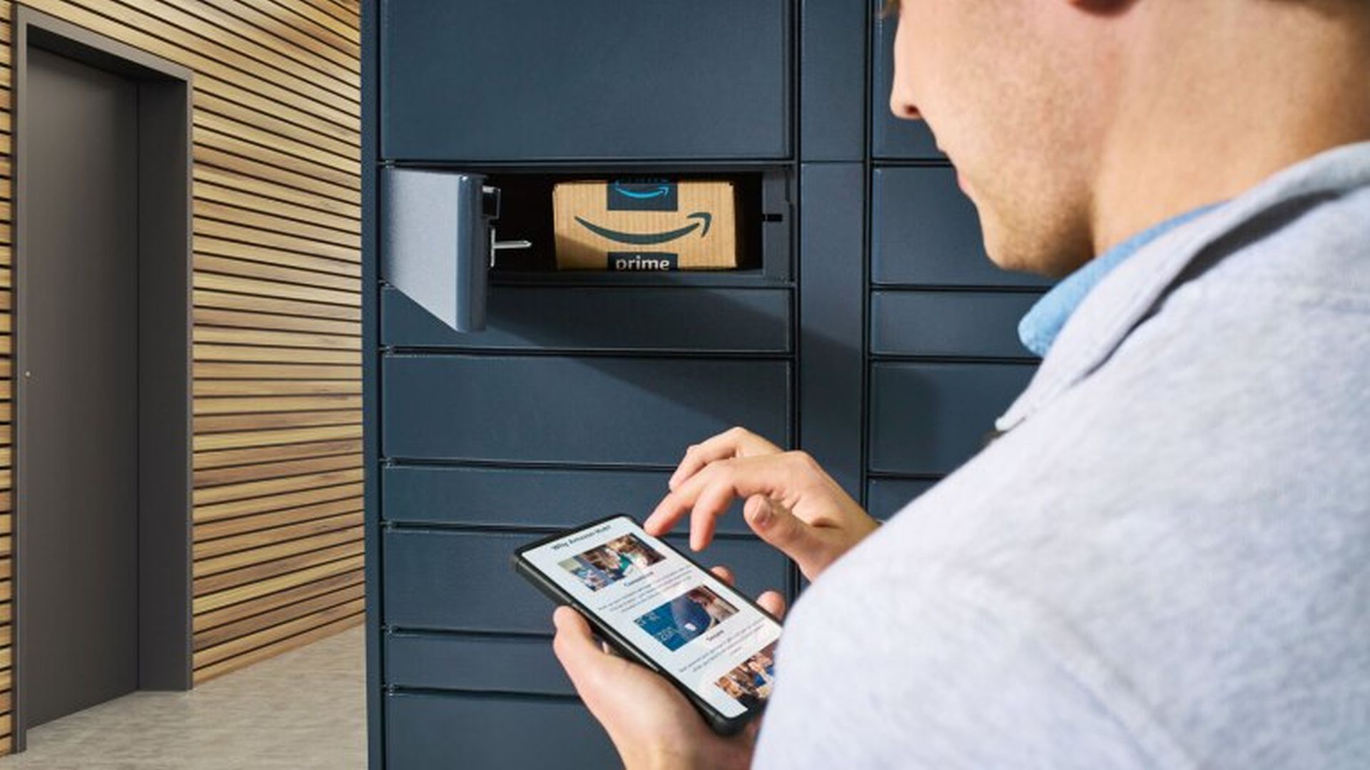 Una persona al telefono, davanti a un Amazon Locker aperto con all'interno una scatola di Amazon Prime
