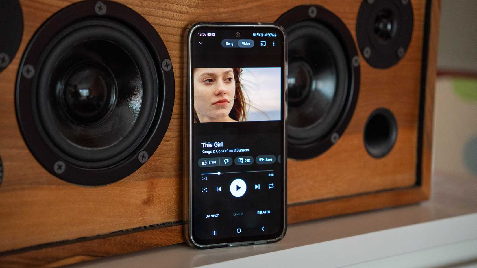YouTube Music Premium em um telefone Samsung apoiado em um alto-falante