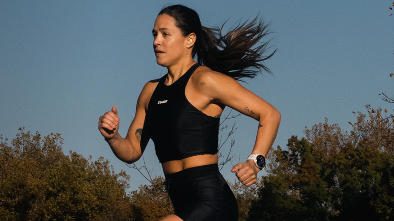 Persona che indossa e corre con Garmin Forerunner 965 