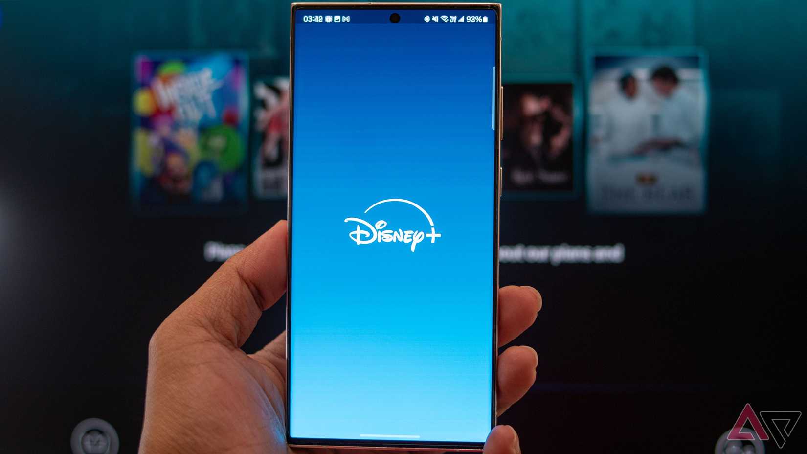 A smartphone being held up showing the Disney+ Logo