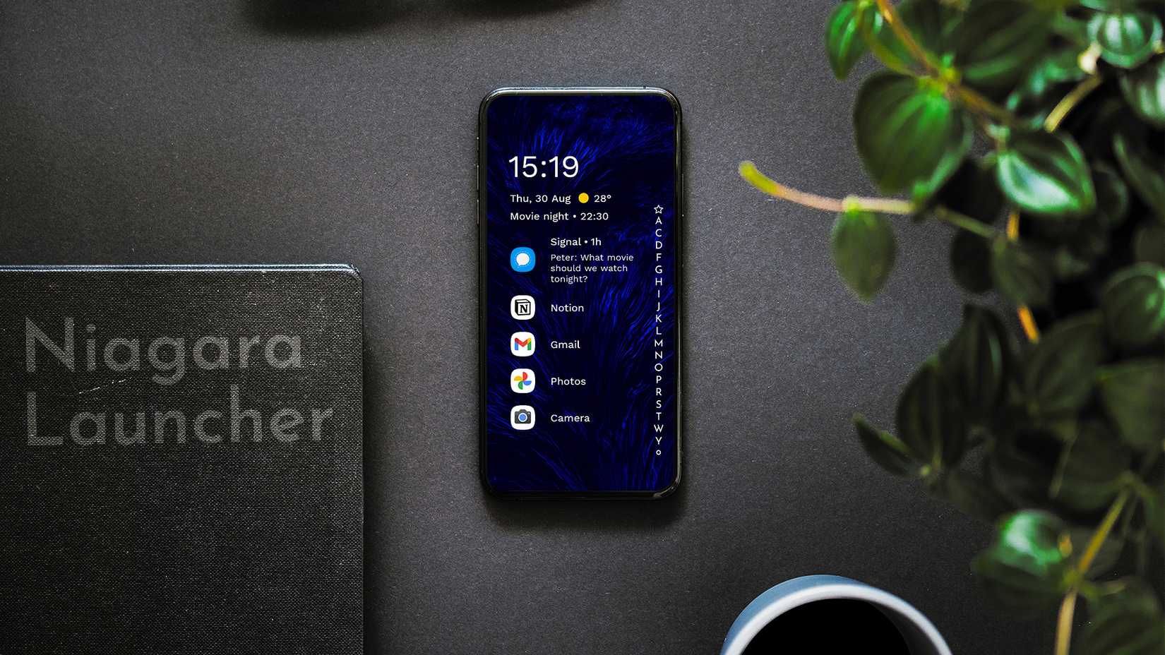 Um smartphone com o lançador Niagara instalado está em cima de uma mesa preta com uma pasta preta.