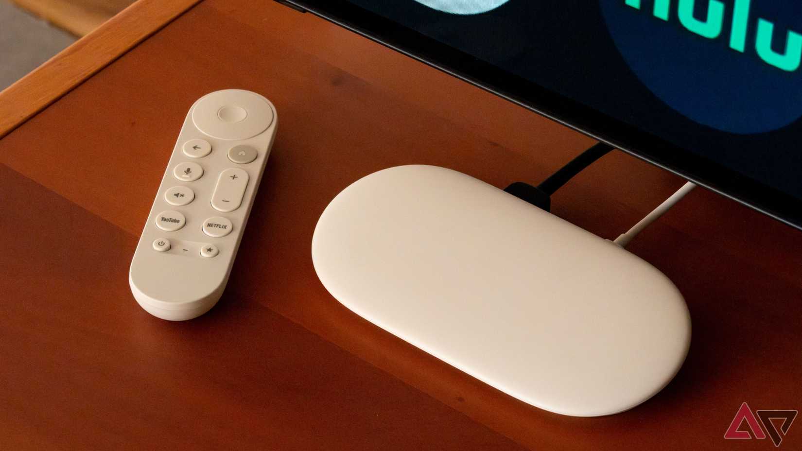 A Google TV Streamer sitting next to a TV and a remote