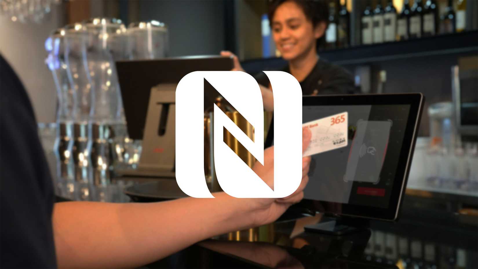The NFC logo with an NFC card payment transaction in the background