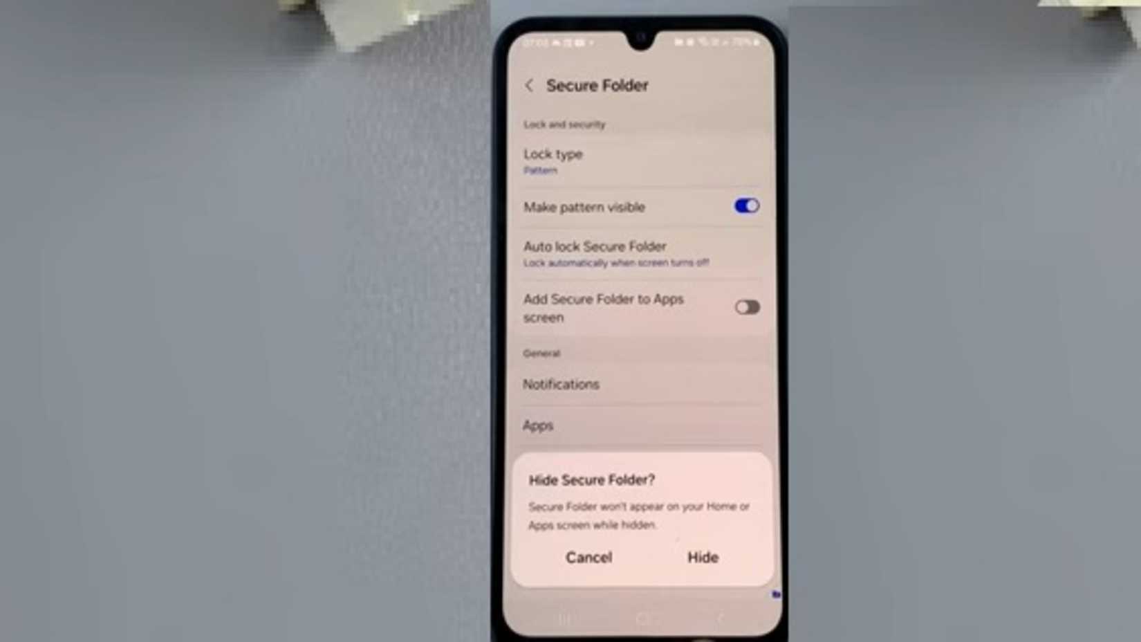 A phone containing the Hiding Secure Folder on Samsung prompt while laying on a table
