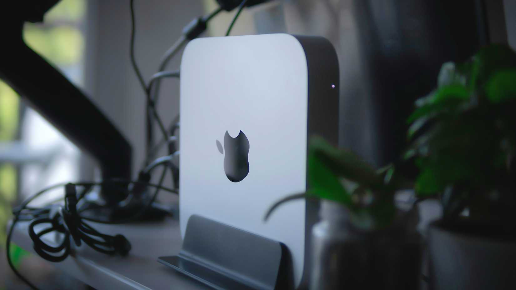 Apple Mac Mini montado em um suporte vertical atrás de um monitor