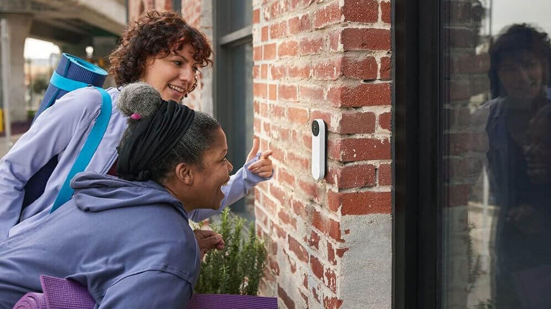 People looking into the Google Nest Doorbell Battery outside a home.