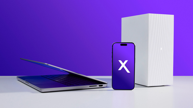 Devices next to each other with the Xfinity logo in the center of a phone on a flat white surface