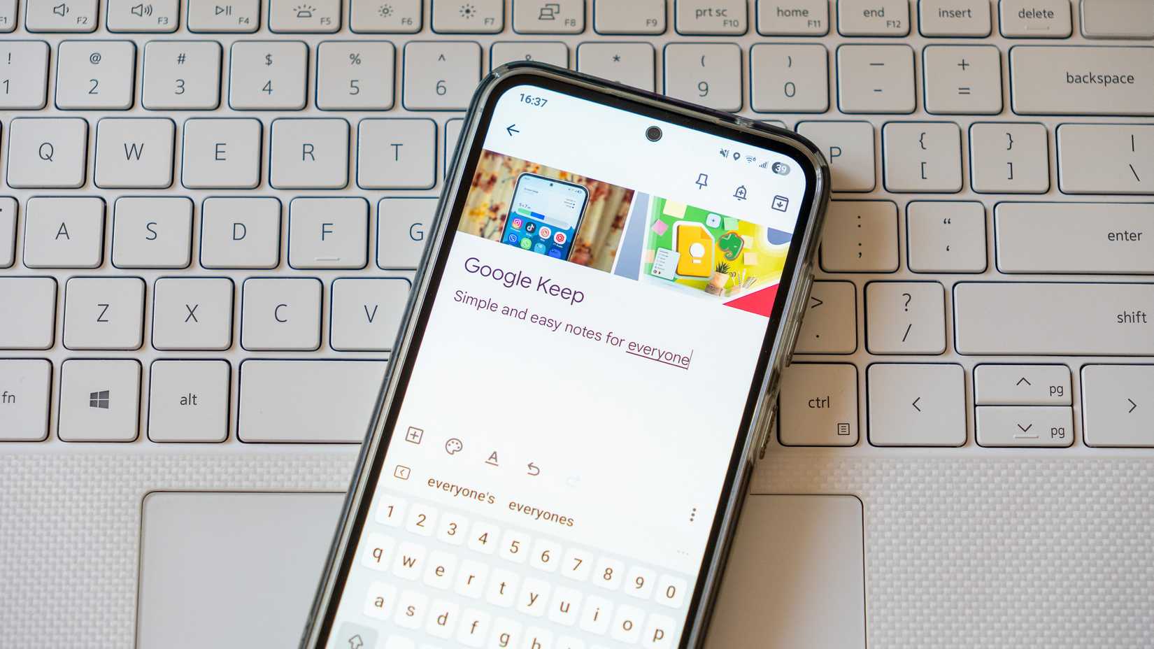 Uma nota do Google Keep exibida em um telefone no teclado de um laptop