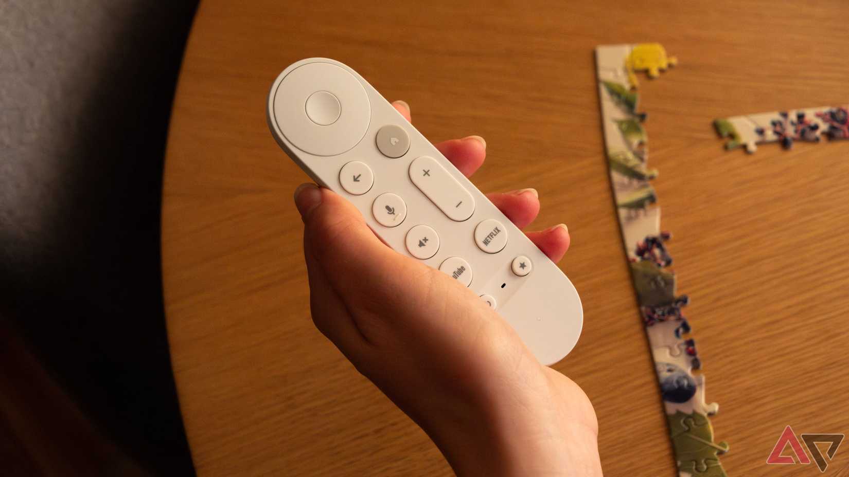 A hand holding a Google TV Streamer remote