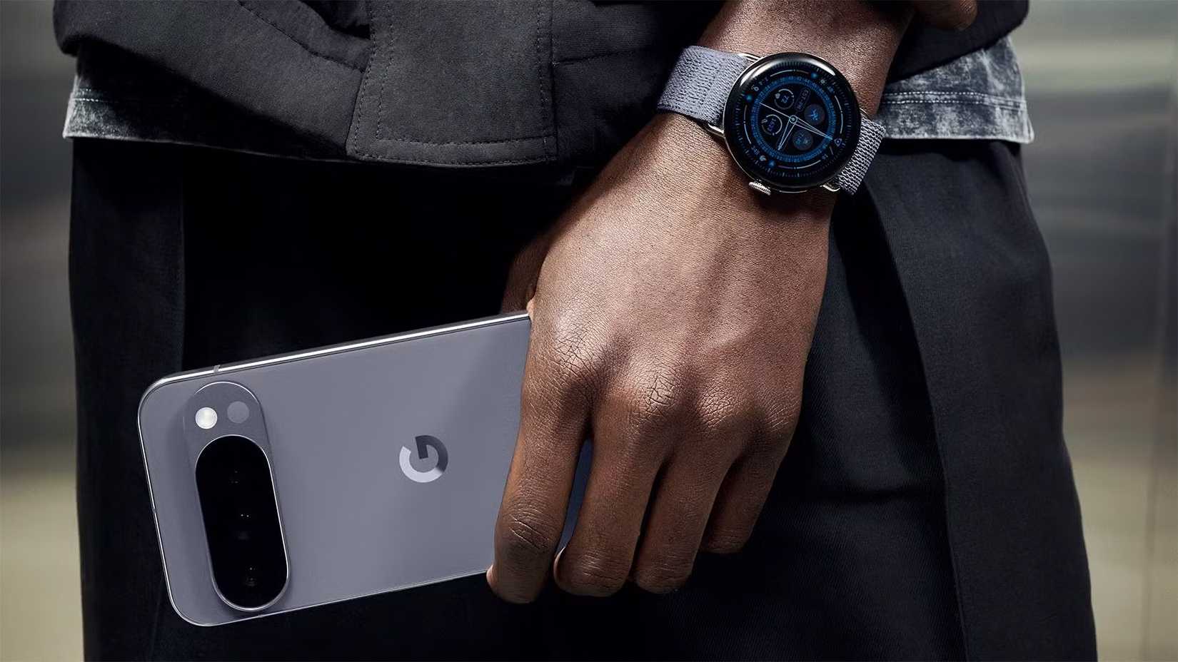 A man holding a Moonstone Pixel 10 Pro and wearing a matching Pixel Watch 4.