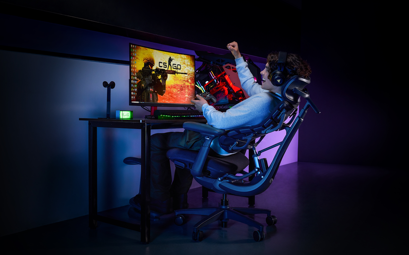 A man playing PC games while sitting on the LiberNovo Omni
