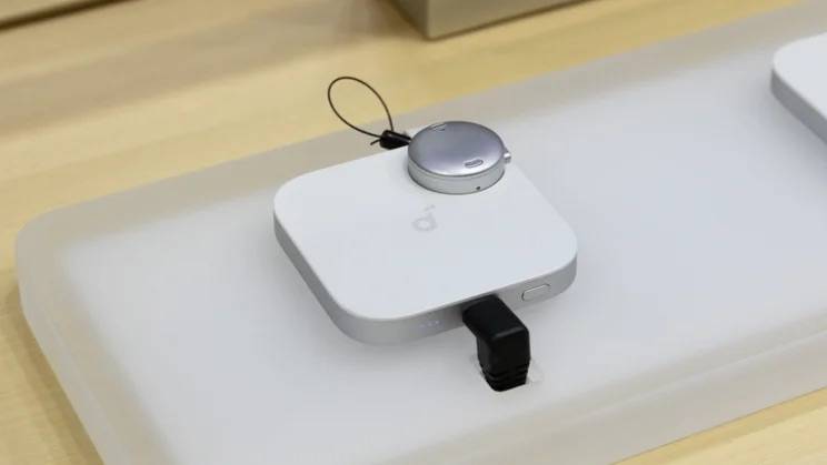 The newly launched Anker Soundcore Work in white laying on top of the charging accessory