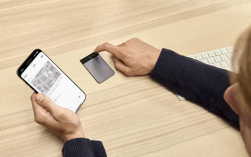 A woman presses her AI voice recorder while taking a photo on her smartphone