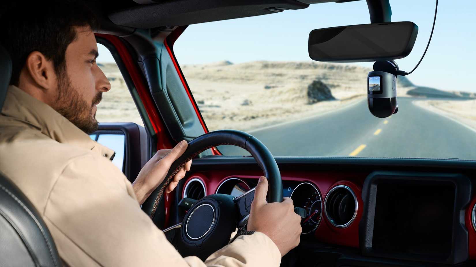 Person driving a car with a 70mai 4K Omni dash cam.