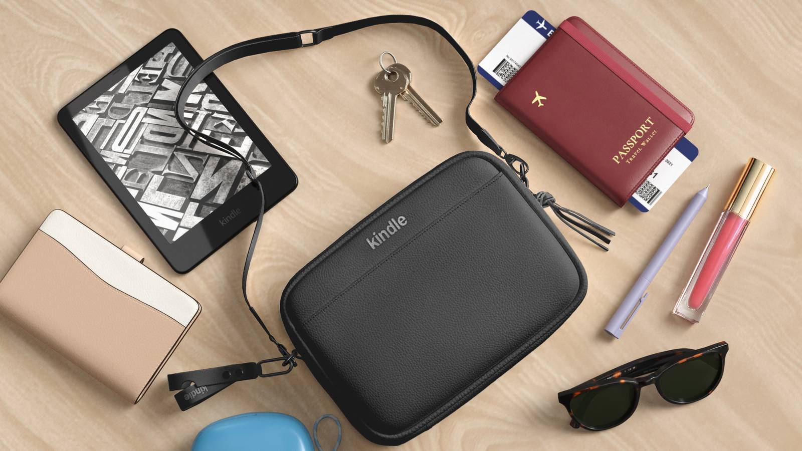 The Kindle sling bag with a number of other accessories, including a Kindle, sunglasses, phone, and more.
