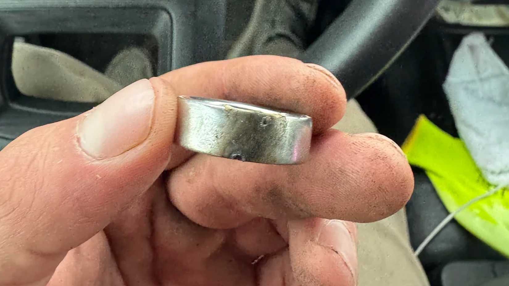 close up of a hand holding a singed-looking Oura