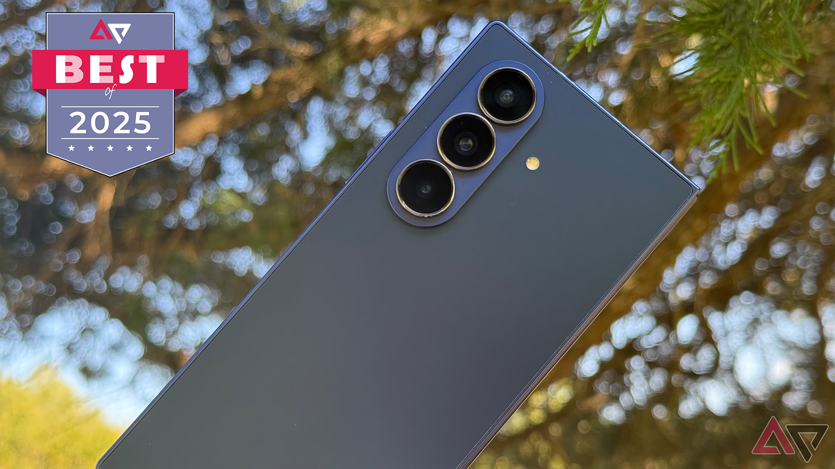 Samsung Galaxy Z Fold 7 held against a tree at dusk.