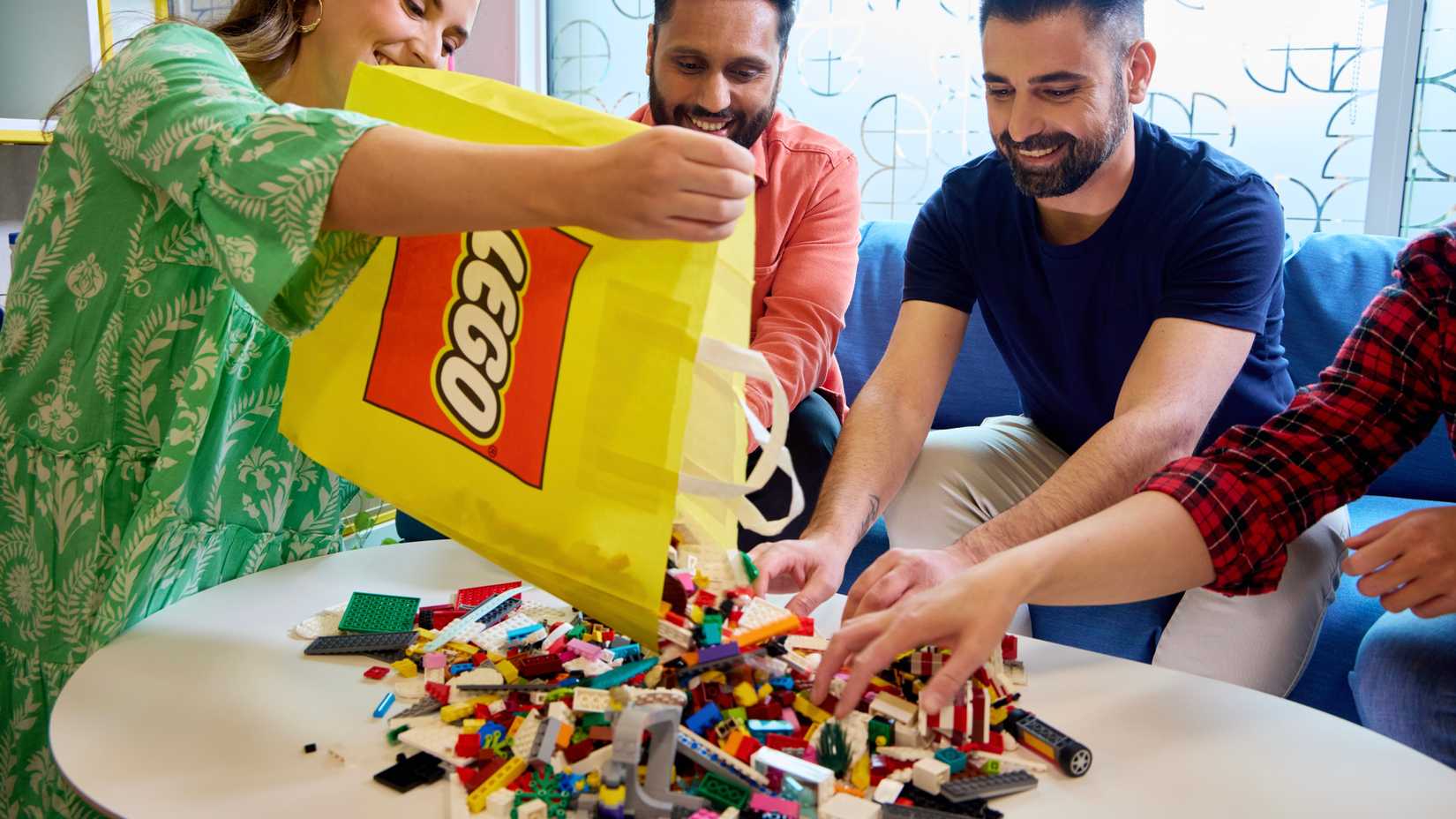 Uma imagem promocional mostrando pessoas construindo Lego