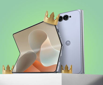 Smartphone dobrável da Motorola apoiado em um pedestal branco com uma coroa dourada apoiada no canto, contra um fundo verde.