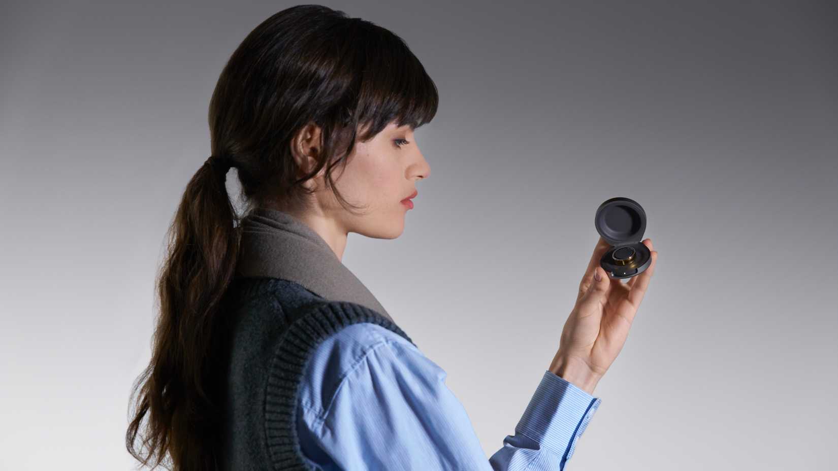 Uma pessoa segurando o estojo de carregamento Oura aberto