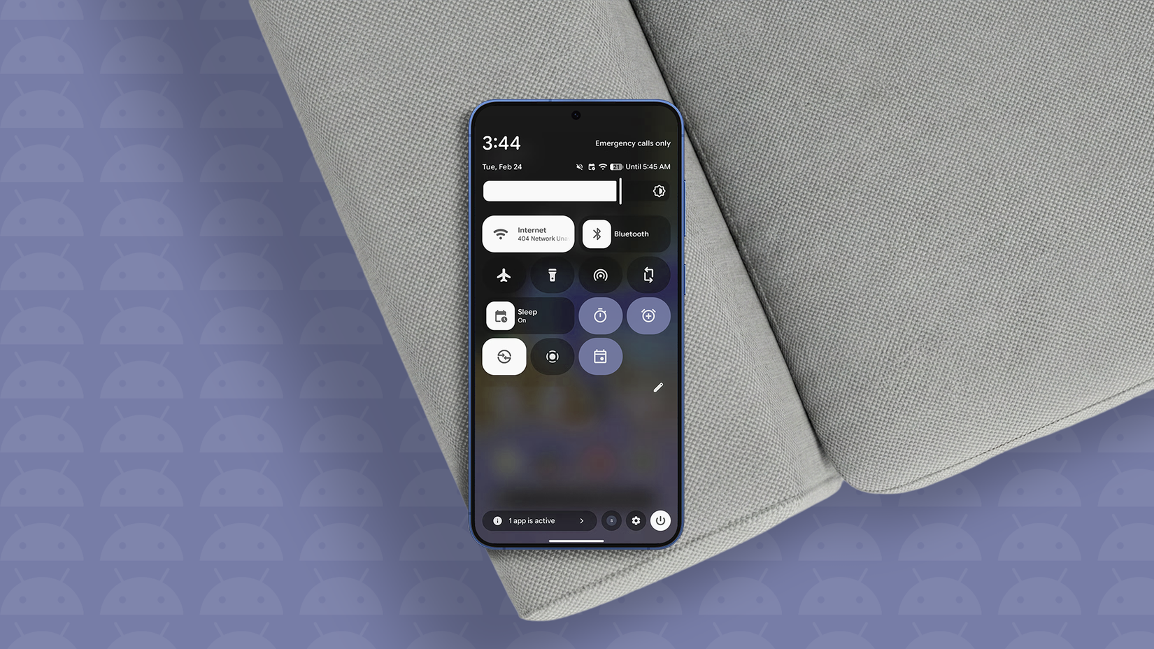 Um smartphone Android com o painel Configurações rápidas aberto, apoiado em um sofá.