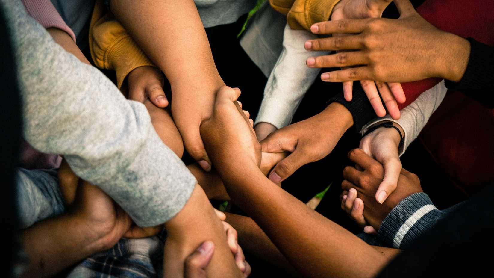 una foto di molte mani che si salutano in una stretta di mano di gruppo