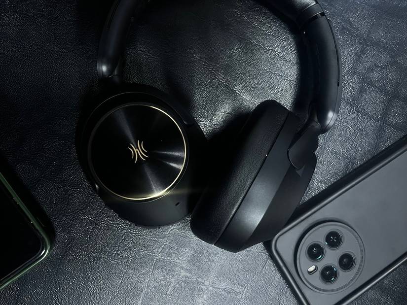 OneOdio Focus A6 nero accanto al telefono nero su un sedile in pelle nera