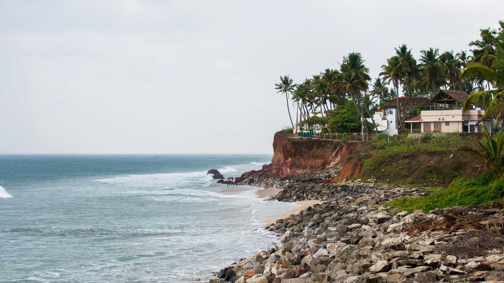 Uma imagem de uma casa em uma costa rochosa com vista para a água