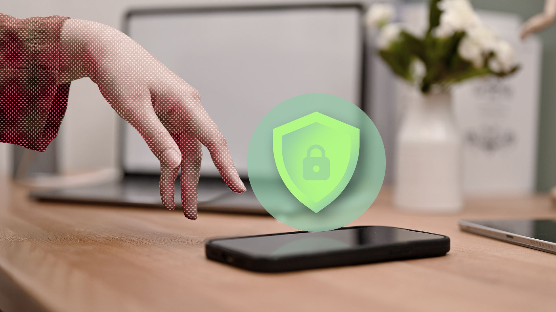 A hand reaching for a smartphone on a desk with a green shield and padlock icon.