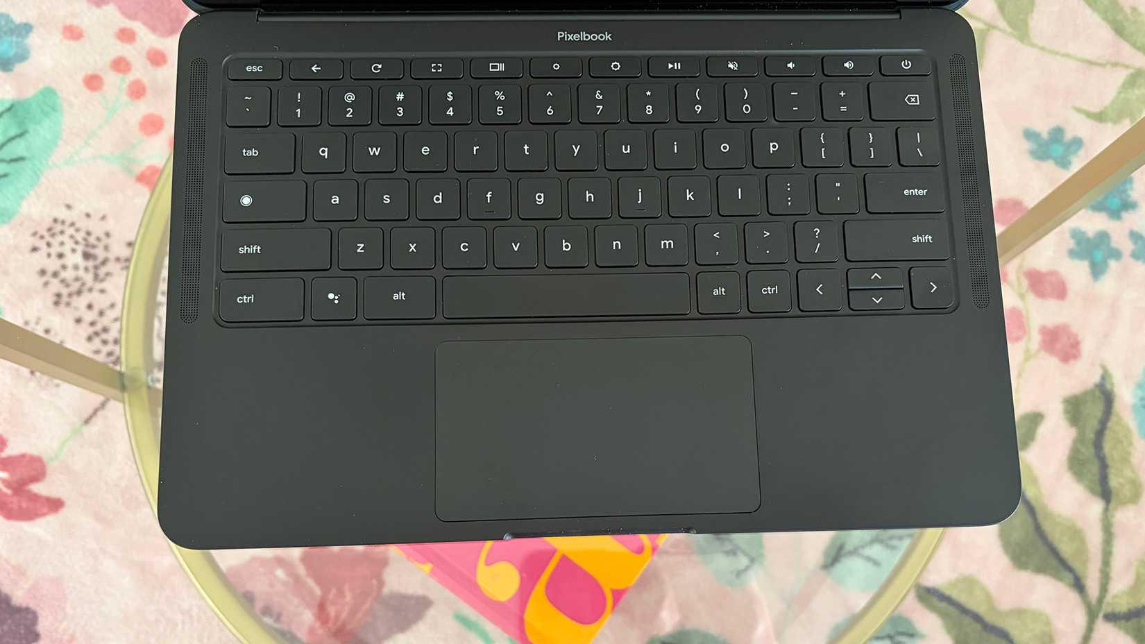 Pixelbook Go keyboard against a table and floral rug