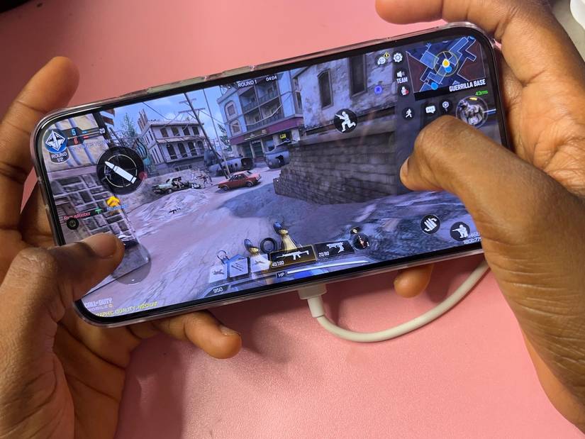 Mãos segurando o telefone e jogando Call of Duty Mobile
