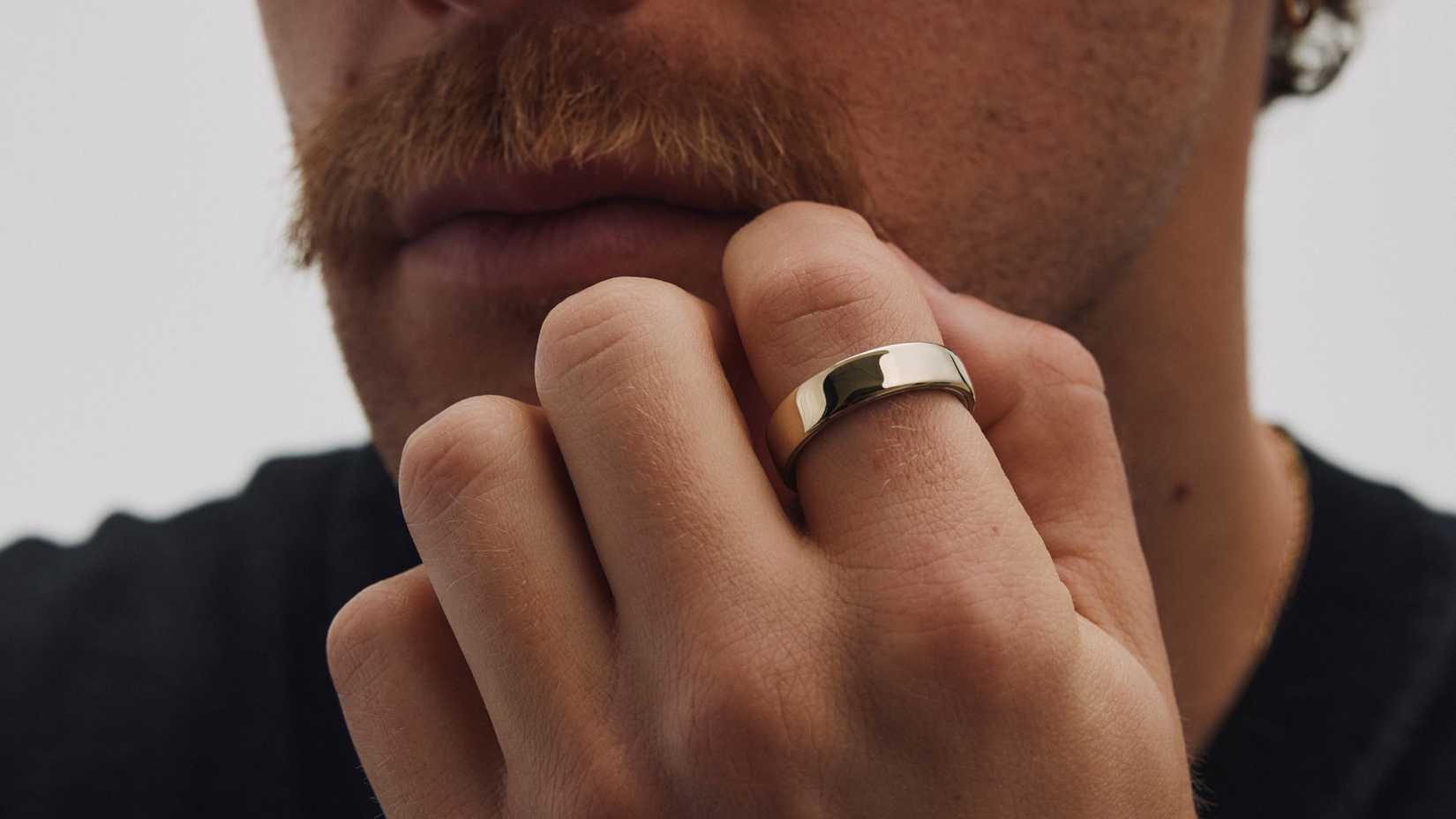 A promotional image of a person wearing the Oura Ring 5