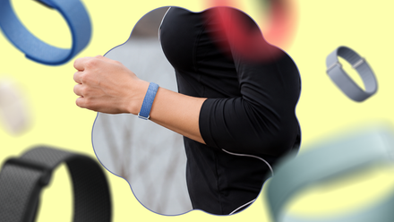 I am dressed in the Fitbit Air, and I like the way it brings again the golden age of health trackers Woman wearing a blue Fitbit Air fitness band with colorful bands floating around in the background.