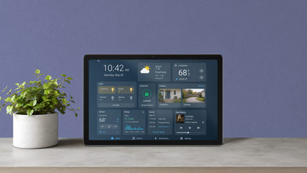 Tablet Android exibindo controles de casa inteligente em uma mesa ao lado de um pequeno vaso de planta.