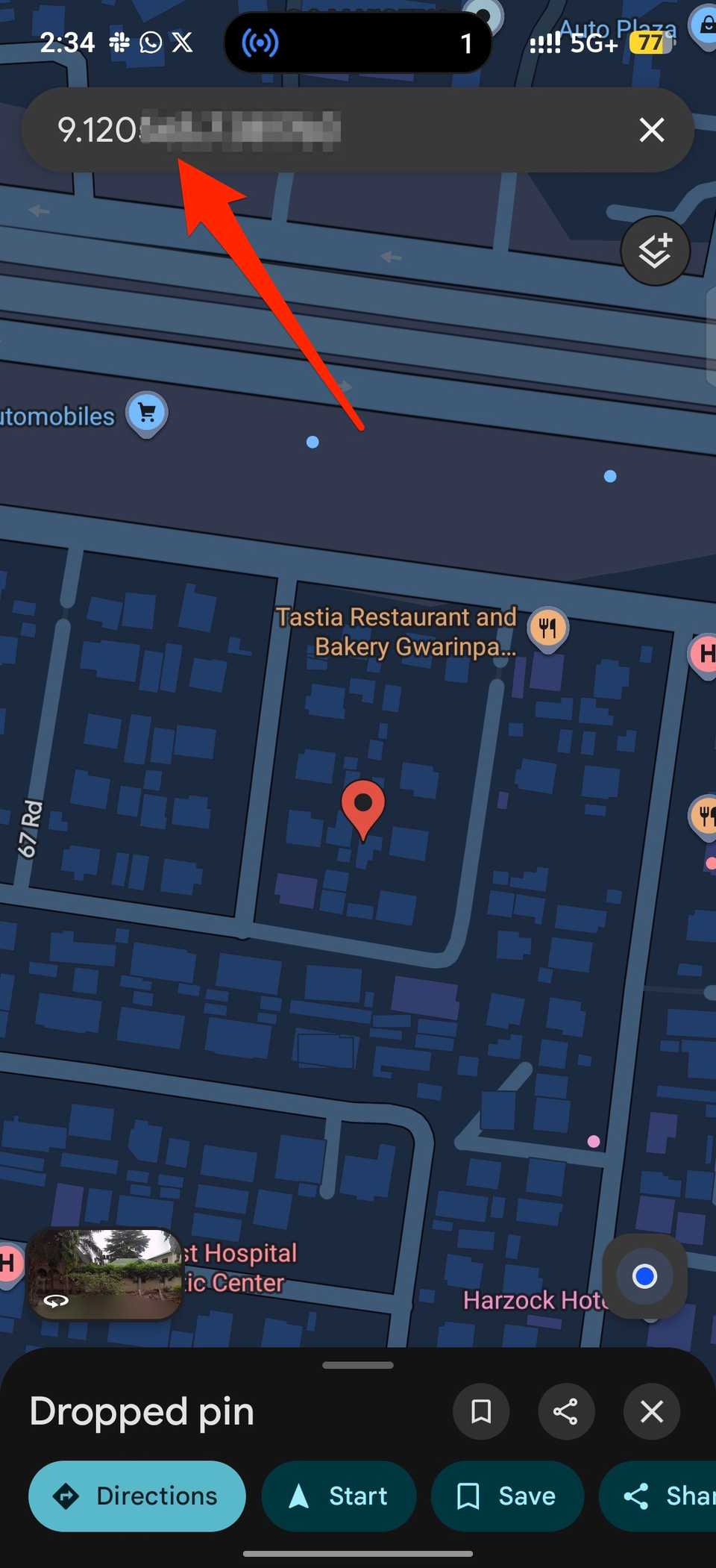 Red arrow pointing to search bar containing location coordinates in Google Maps