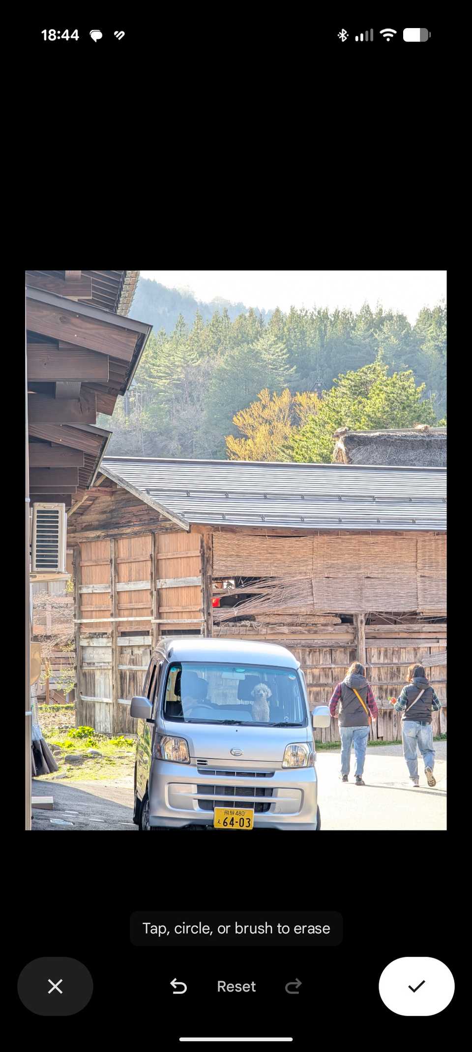 An image in Google Photos editor with a mini van with people in the background