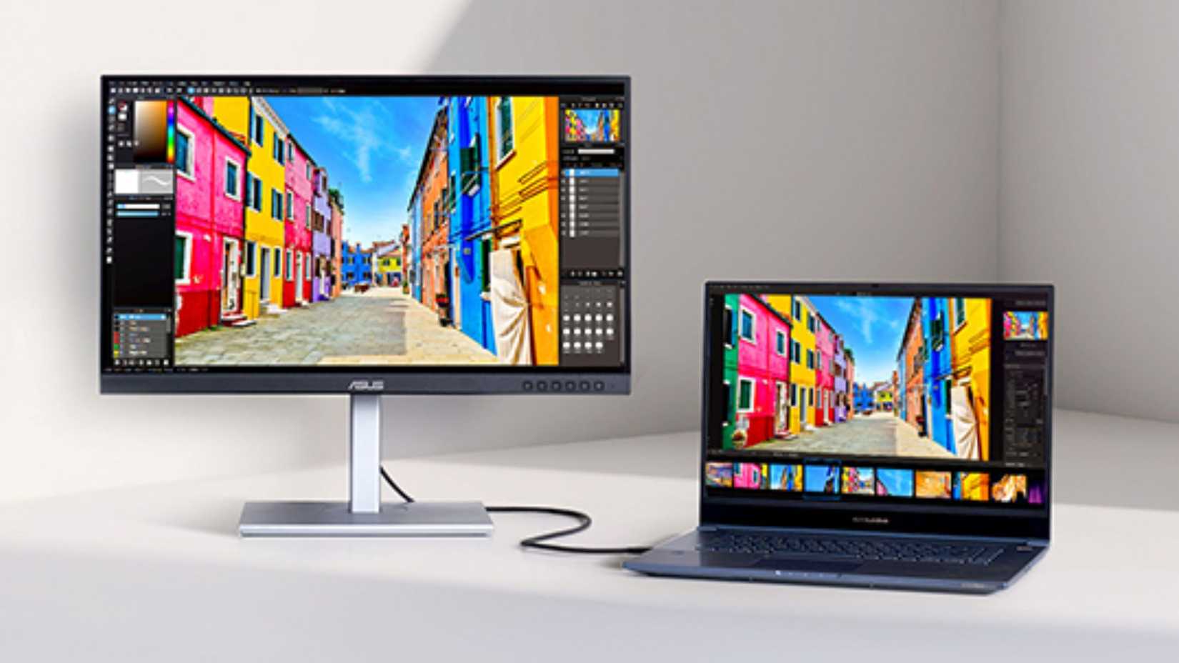 Monitor professionale ASUS ProArt Display PA279CV accanto a un portatile