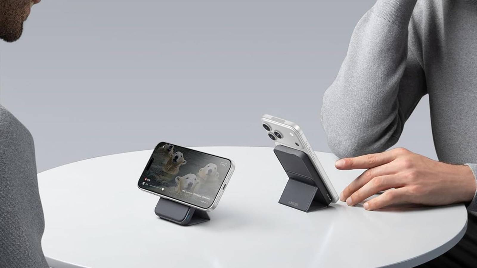 Two people looking and using the Anker 622 Magnetic Power Bank