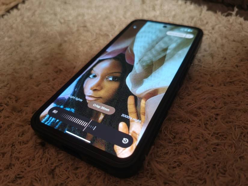 Smartphone resting on plush carpet displaying photo editing with Google Photos' Moods