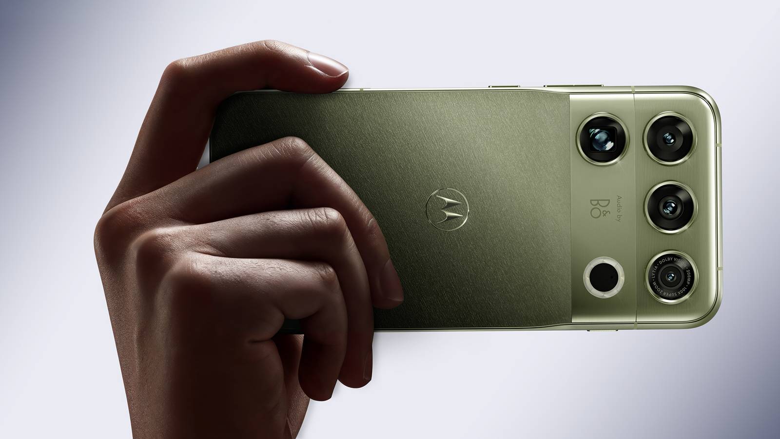 A hand holding the Motorola Signature 27 in Capulet Green