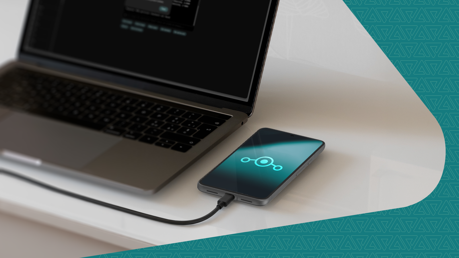 A smartphone displaying the LineageOS logo connected to a laptop via USB cable.