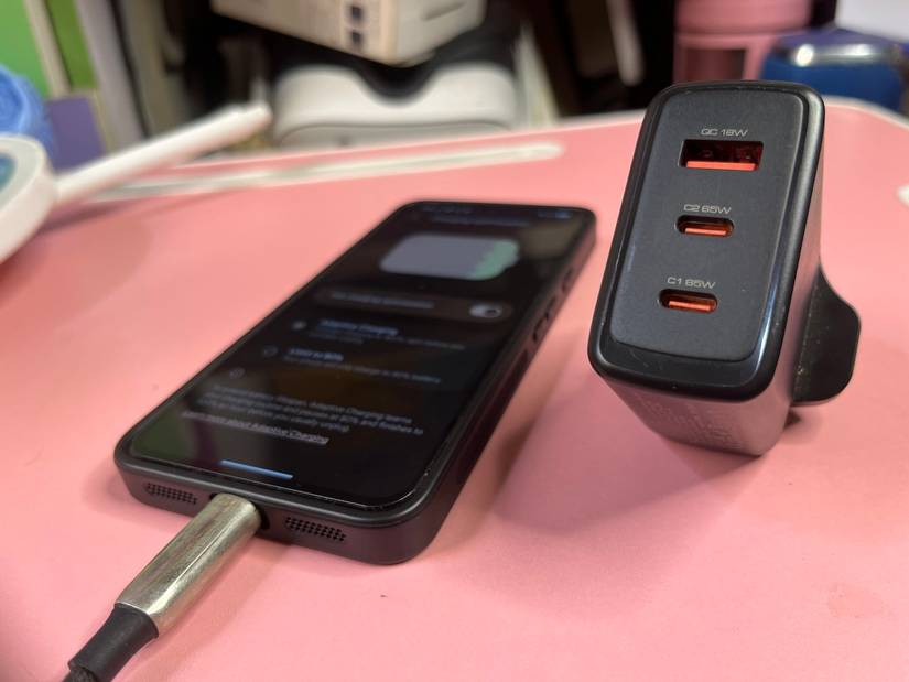 black multi-port fast charger plug beside smartphone connected to USB cable